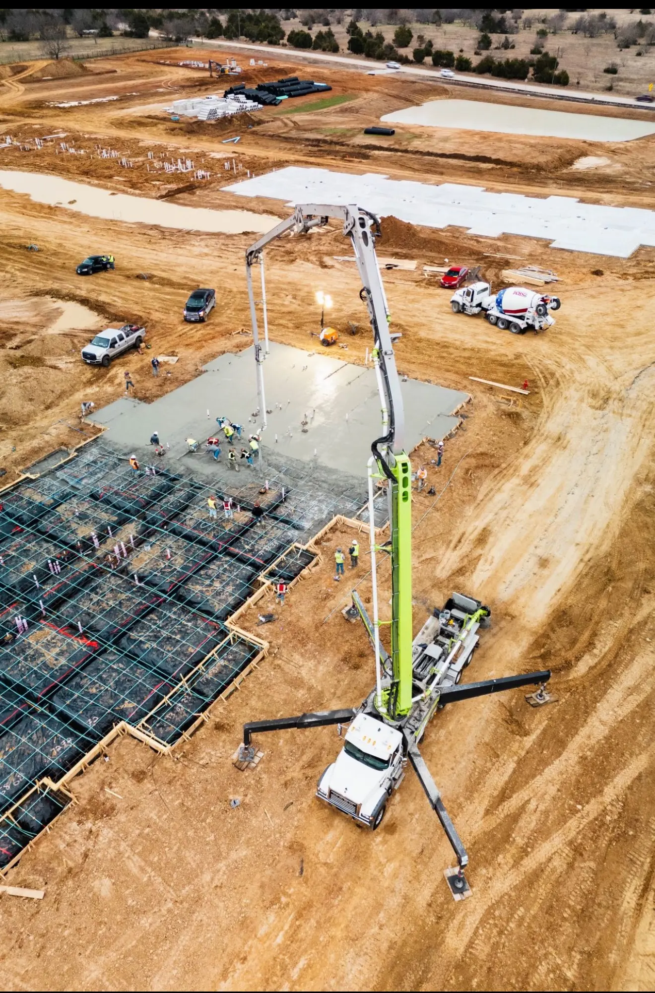 Vertical aerial view of a mobile concrete pump placing concrete at a prepared foundation