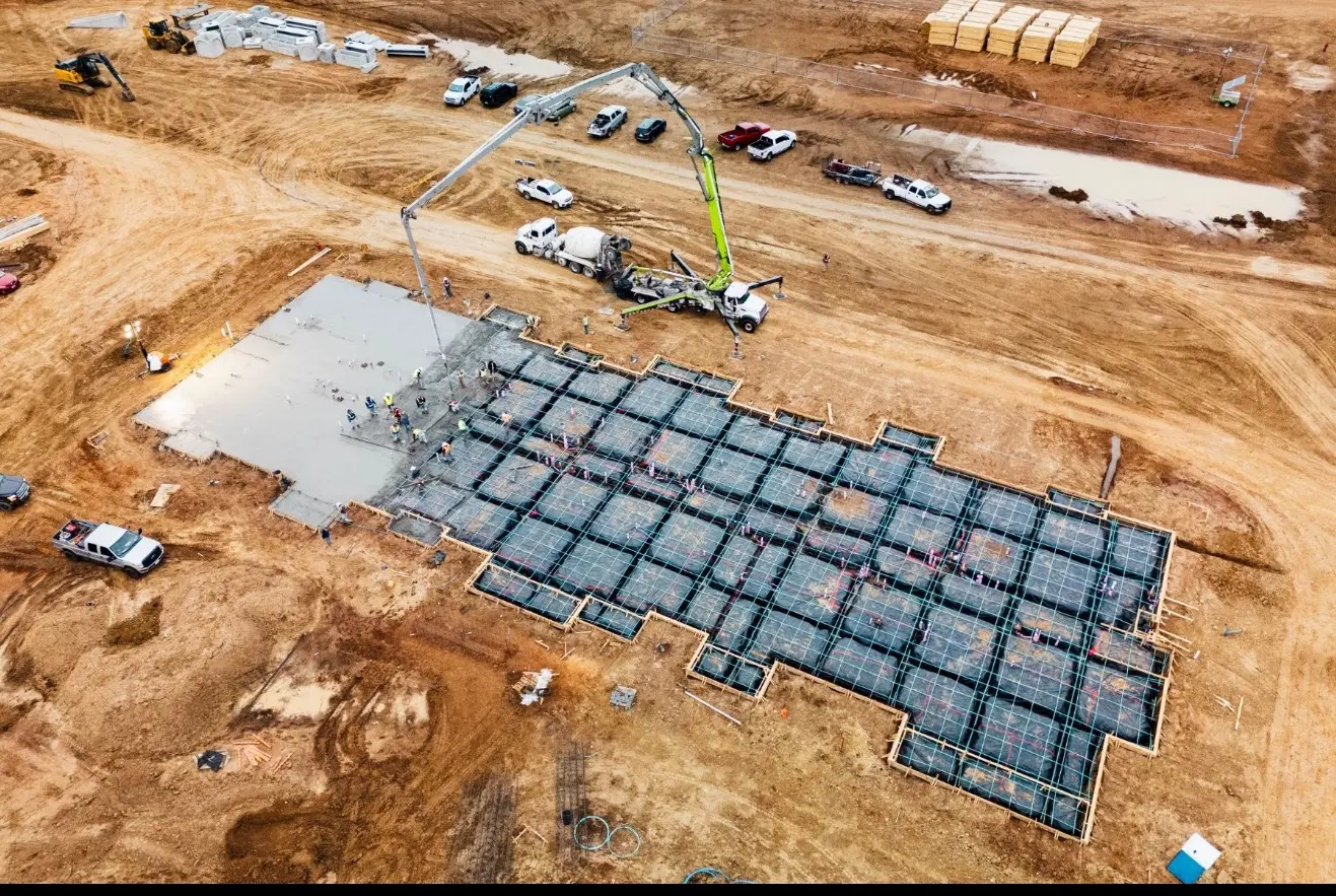 Aerial view of concrete placement across a formed and reinforced foundation area